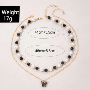 Detail van de dubbellaagse ketting met vlinderhanger, kralen en maatspecificaties