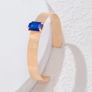 Détail de la pierre bleue sur un bracelet jonc vintage en métal martelé fini doré