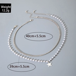 Detail van gelaagde smaragdgroene ketting met strass ster en parelketting afmetingen