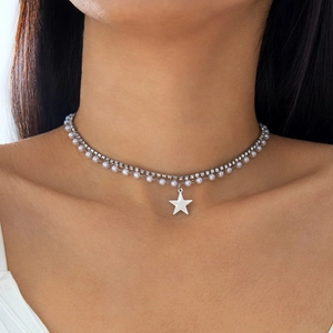 Detail van dubbele choker met ster hanger, witte parels en fonkelende strass steentjes
