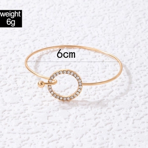 Détail d'un bracelet doré de 6g avec pendentif cercle en strass et diamètre de 6cm