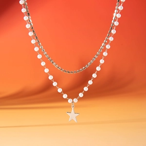 Macro-opname van een dubbellaagse ketting met parels, strass en een ster hanger