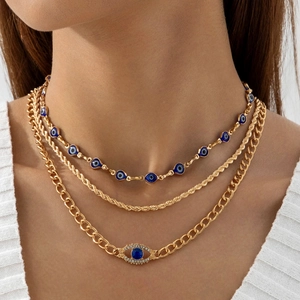 Detail van de drielaagse gouden Evil Eye ketting met blauwe edelsteen en stoere cubaanse schakel