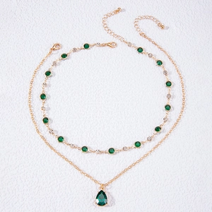 Collier double épaisseur doré avec pendentif goutte vert émeraude et détails en cristal