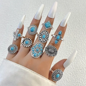 Detailed close-up of bohemian silver rings set with turquoise flowers and cactus motifs