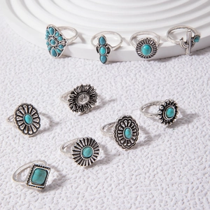 Close-up of 10-piece vintage silver ring set with turquoise stones and floral engravings