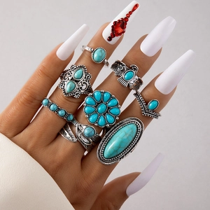 Close-up of bohemian silver rings set with turquoise stones and floral eagle designs