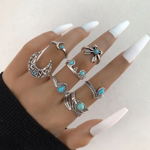 Detail of 7-piece bohemian ring set with turquoise stones and celestial metal patterns