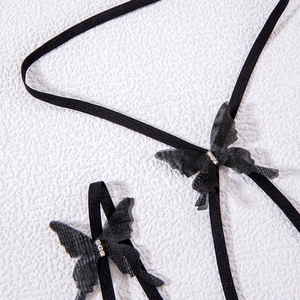 Detail of black elastic leg chain featuring delicate mesh butterflies and sparkling rhinestones