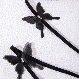 Detailed view of black layered mesh butterfly leg rings with sparkling white rhinestones
