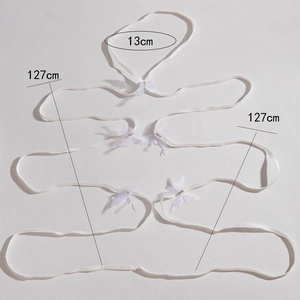 Detail view of white elastic leg garter with butterfly charms and 127cm ribbon ties