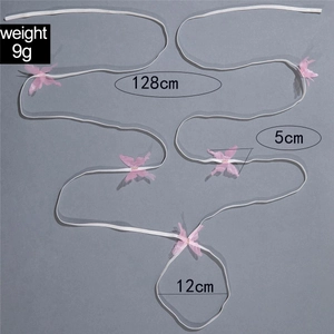 Detail of white elastic leg chain with pink mesh butterflies and glitter accents