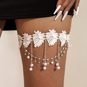 Detail of white lace leg garter with pearl fringes and butterfly charms for women