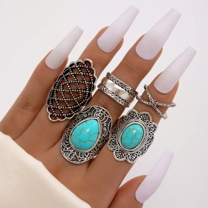 Dettaglio del set di anelli bohémien con turchese, incisioni vintage e forme geometriche a V