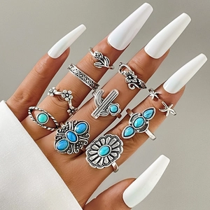 Dettaglio del set di 10 anelli boho in argento con turchese sulla mano
