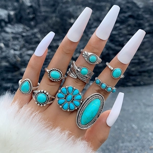 Dettaglio di anelli boho con turchese, finitura argento vintage e incisioni a piuma