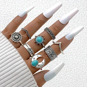 Dettaglio di set anelli boho vintage argento con pietre turchesi e incisioni luna