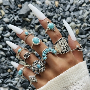 Set di anelli vintage boho con pietre turchesi e motivi a serpente sulla mano della modella