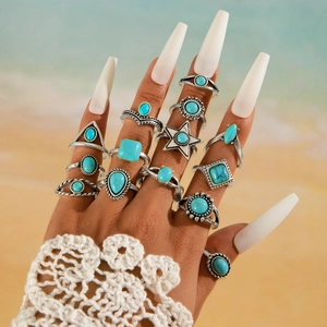 Dettaglio di un set di 13 anelli boho in argento vintage con turchese sulla mano