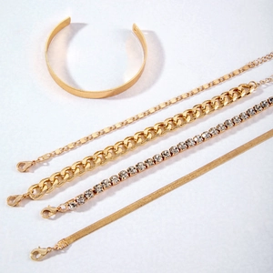 5-piece gold-toned bracelet set featuring chunky curb chain and rhinestone tennis link