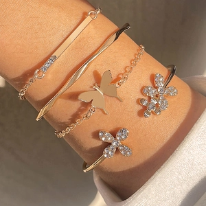 Elegantes Set aus roségoldenem Armband mit Schmetterling und glitzernden Armreifen mit Sternen