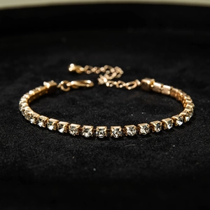 Detail of gold tennis bracelet with cubic zirconia claw setting and lobster clasp