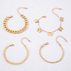 Four-piece layered gold chain bracelet set featuring butterfly charm and faux pearls