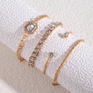 Detail of a 4-piece gold bracelet set featuring crystals and a twisted chain design