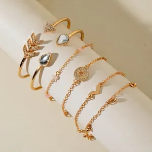 Detailed view of six-piece gold bracelet set with faux gems and geometric charms