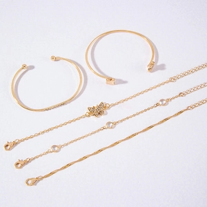 Detail view of 5-piece gold jewelry set including butterfly charm and twisted chains