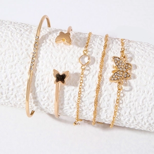 Close-up of 5-piece gold bracelet set with butterfly charms and sparkling crystals
