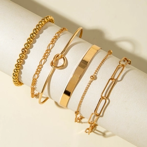 Detailed view of 6-piece gold-toned minimalist bracelet set on a neutral display stand