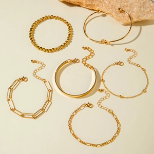 Detail of 6-piece gold polished metal bracelet set featuring curb and cable links