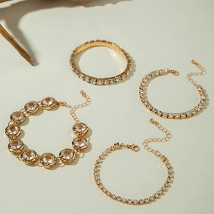 Detail view of 4-piece gold bracelet set with tennis chains and crystal bangles
