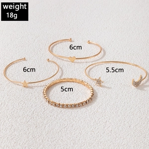 Set of 4 gold-tone alloy bangles featuring star and heart charms with crystal detailing