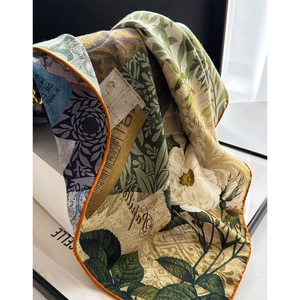 Silk wool scarf with floral print and orange rolled edges on a white background