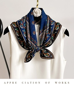 Detail of silk wool scarf with navy blue floral print and satin finish on a white dress