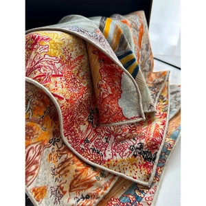 Close-up of silk wool scarf showing artistic floral print and rolled hem detail