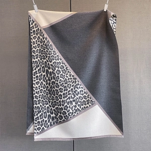 Detailed view of the knit cashmere-like scarf texture with modern geometric leopard patterns