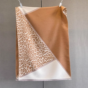 Close-up of leopard print and geometric color block scarf with fine short fringe edges