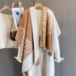 Close-up of leopard print collar detail and wool blend fringe on an elegant beige shawl