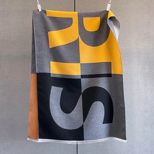 Detail of knit scarf with orange and grey geometric color block and PARIS typography