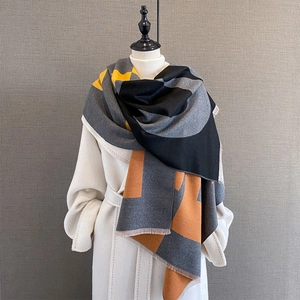 Detail of color block geometric pattern scarf with fine tassel edges on a mannequin