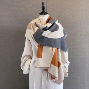 Chic geometric color-block oversized shawl scarf with fringe on a white coat