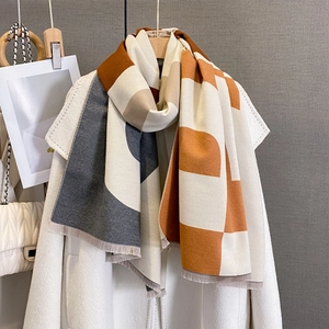 Detail of color-block scarf with tassels on white coat and quilted luxury handbag