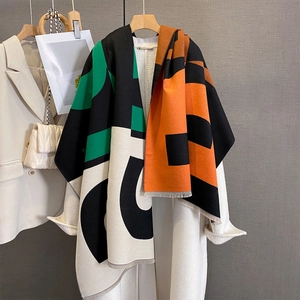 Detail of color-block knit scarf with frayed edges and vibrant geometric patterns