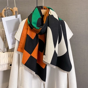 Fashion geometric color-block scarf with fringes on a white coat, stylish winter shawl