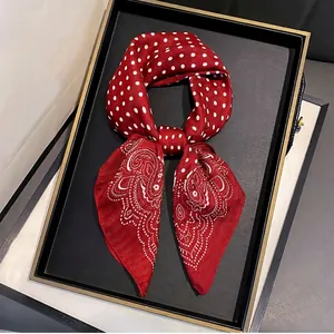Red silk square scarf with white polka dots and paisley patterns in a gift display tray