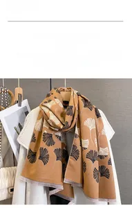 Close-up of brown cashmere-like scarf with ginkgo leaf jacquard and fringe edges