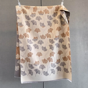 Detail of cashmere scarf with yellow ginkgo leaf pattern and soft tassel edges